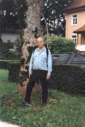 Photo von Erwin Thomasius neben einem mit Moos, Algen und Flechten bewachsenen alten Baumstamm an der  Kardinal-Faulhaber-Straße in Traunstein in Oberbayern aus dem Jahr 2006. Photo: Ralf Splettstößer
